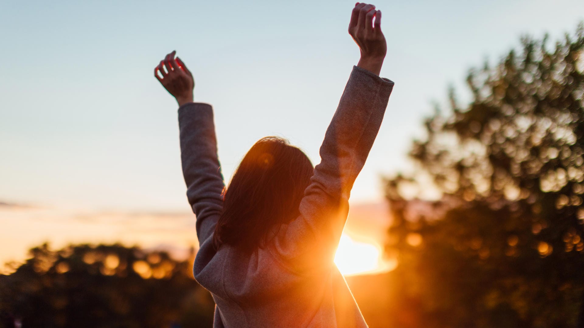 Eine Frau beobachtet den Sonnenuntergang: In stressreichen Phasen ist es wichtig, zwischendurch immer wieder Energie zu tanken und die eigenen "Akkus" aufzuladen.