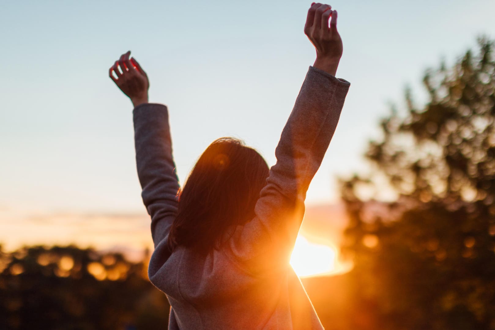 Eine Frau beobachtet den Sonnenuntergang: In stressreichen Phasen ist es wichtig, zwischendurch immer wieder Energie zu tanken und die eigenen "Akkus" aufzuladen.