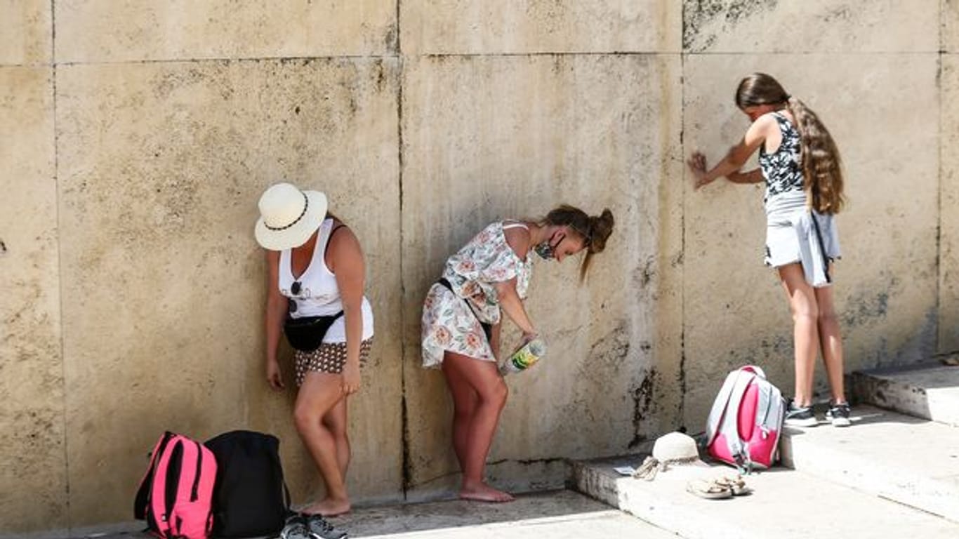 Touristinnen kühlen sich am Trevi-Brunnen in Rom ab (Archiv).