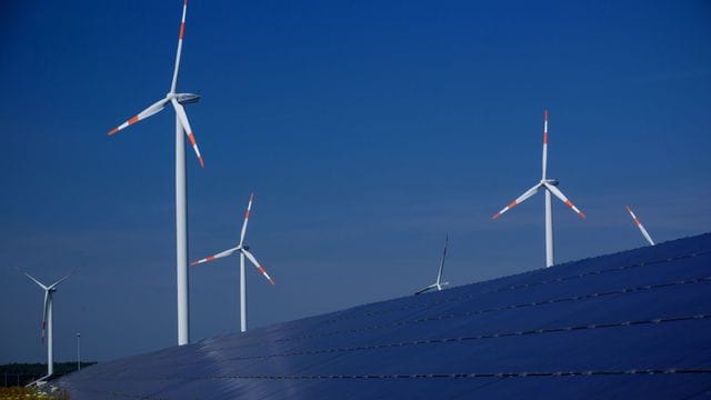 Windräder zur Stromerzeugung drehen sich in Mecklenburg-Vorpommern hinter einem Solarpark. Windräder zur Stromerzeugung drehen sich in Mecklenburg-Vorpommern hinter einem Solarpark.