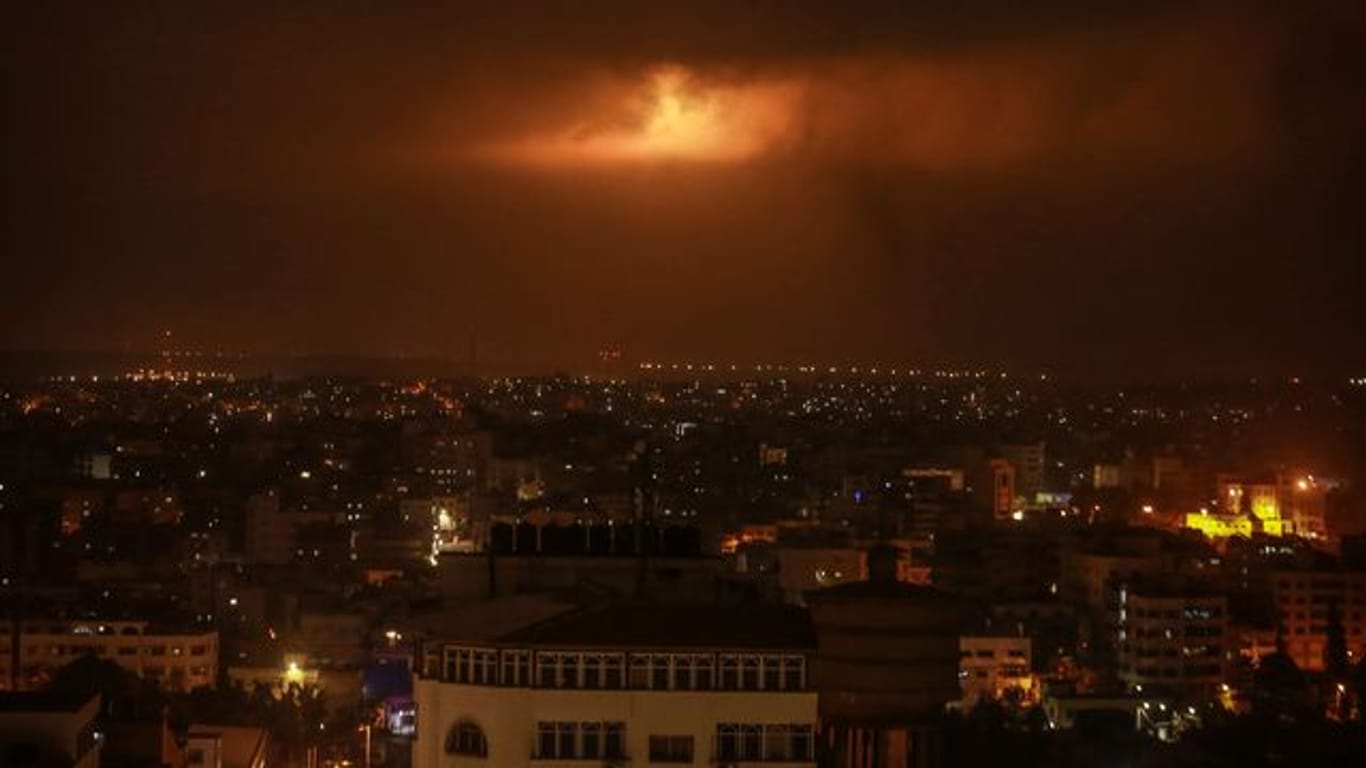 Von der israelischen Armee abgefeuerte Leuchtbomben erhellen den Nachthimmel über Gaza.