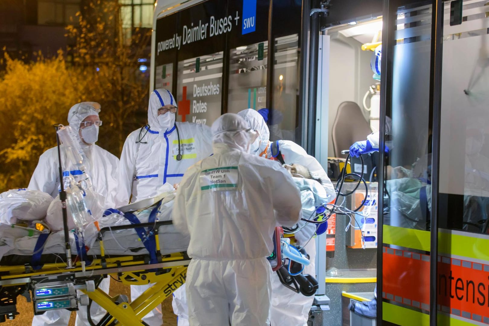 Ein Corona-Patient wird in einen Intensivtransport verlagert (Archivbild). In Deutschland infizieren sich noch immer über 20.000 Menschen täglich.