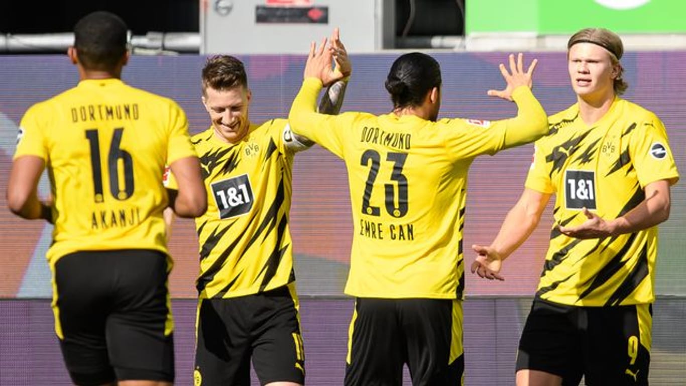 Dortmunds Matchwinner Erling Haaland (r) wird von seinen BVB-Teamkollegen in Wolfsburg gefeiert.