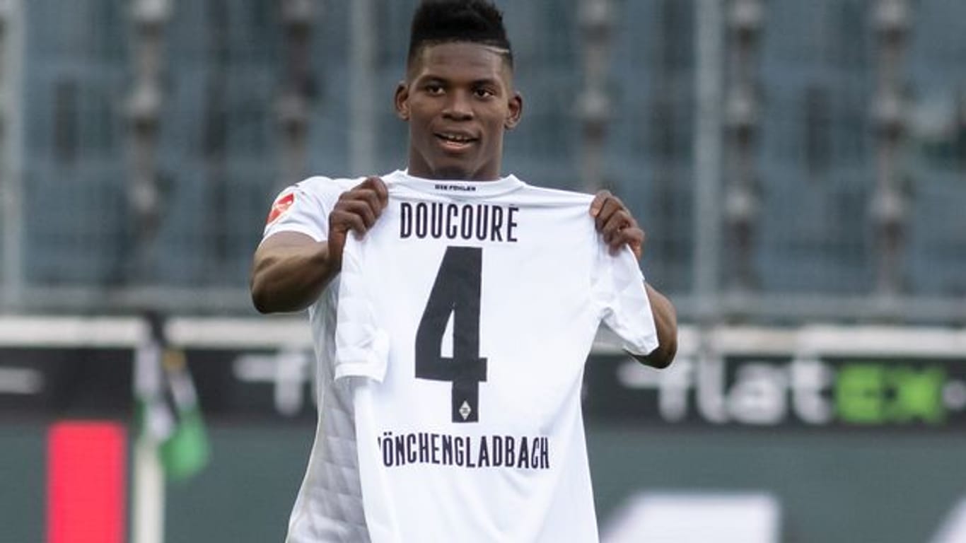 Mönchengladbachs Breel Embolo hält nach seinem Tor zum 1:0 ein Trikot von Mamadou Doucoure hoch.