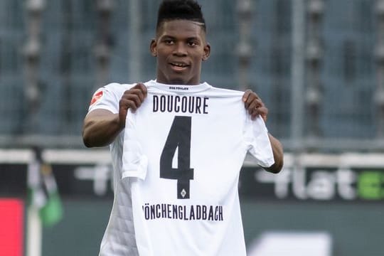 Mönchengladbachs Breel Embolo hält nach seinem Tor zum 1:0 ein Trikot von Mamadou Doucoure hoch.
