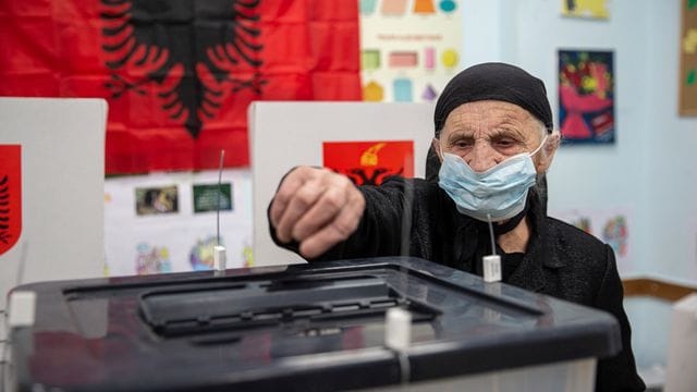 Eine Frau wirft in Tirana ihren Stimmzettel in eine Wahlurne.