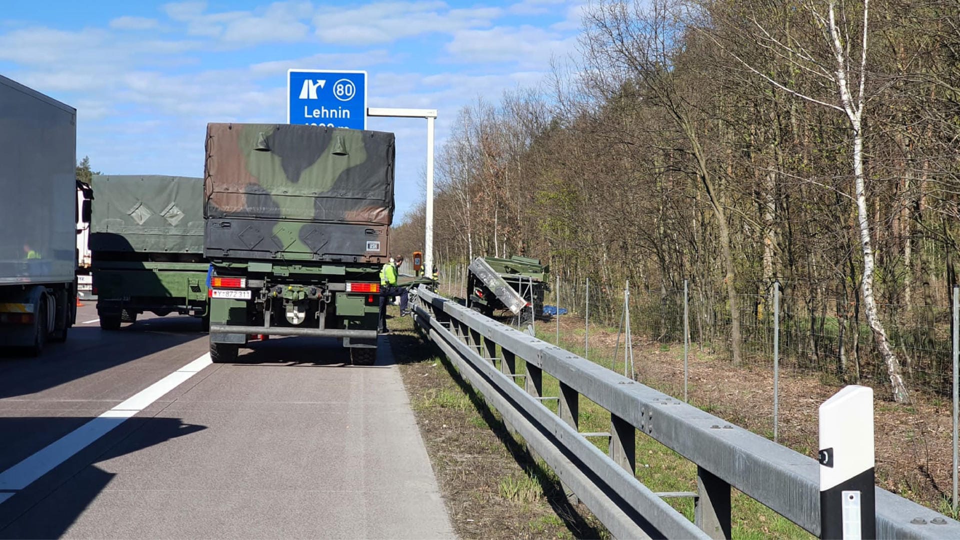 Unfall auf der A2: Ein Lastwagen der Bundeswehr steht auf dem Standstreifen der A2, während rechts neben der Fahrbahn ein beschädigtes Fahrzeug liegt.