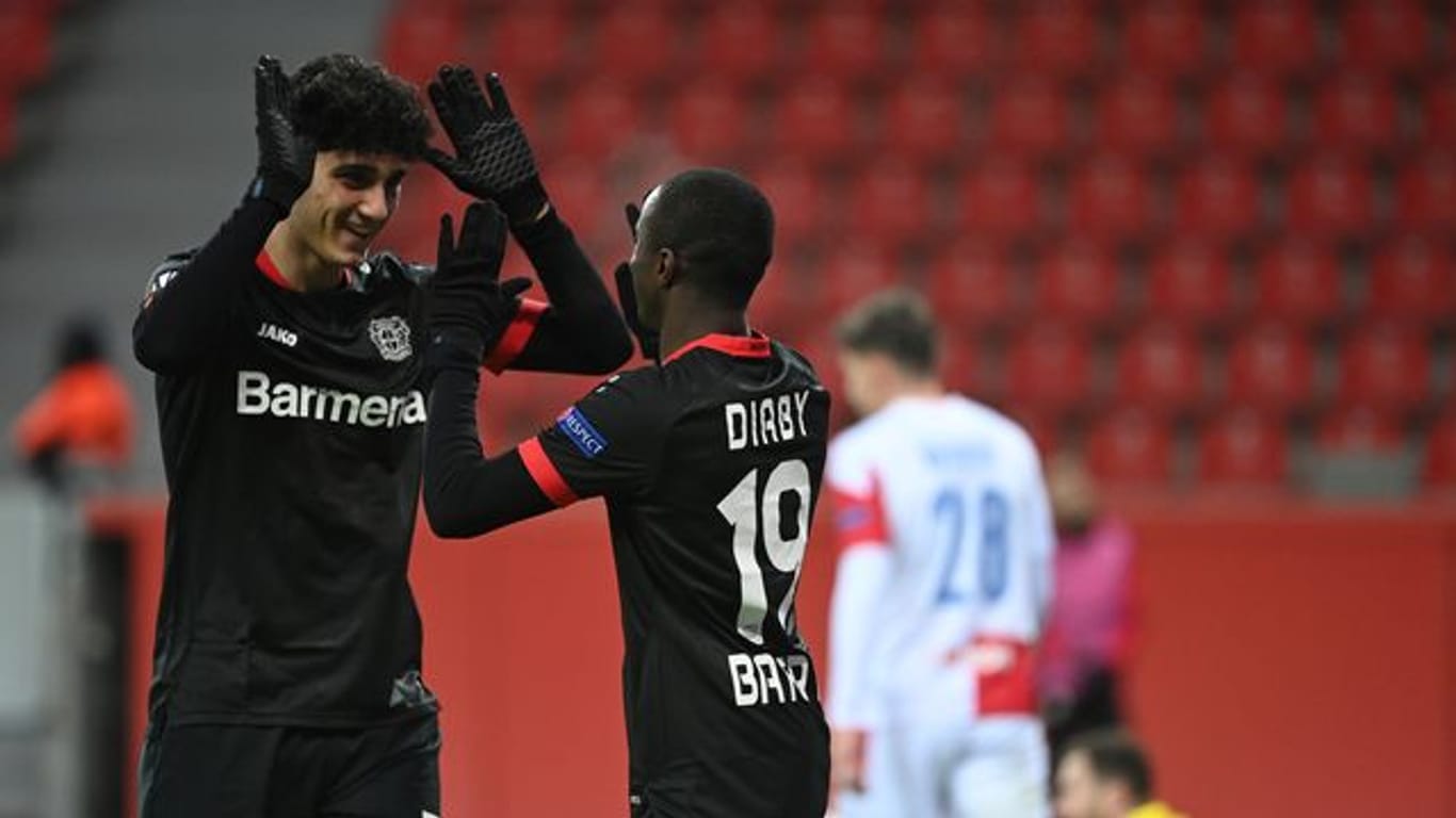 Erhält bei Bayer Leverkusen einen Profivertrag: Emrehan Gedikli (l) klatscht nach einem Treffer in der Europa League mit dem Torschützen ab.