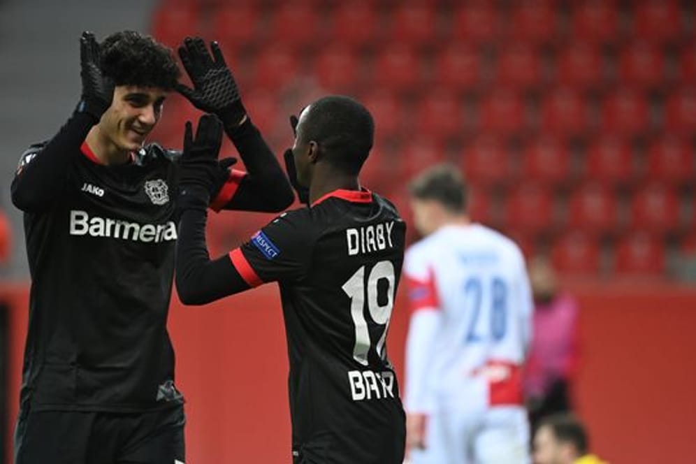 Erhält bei Bayer Leverkusen einen Profivertrag: Emrehan Gedikli (l) klatscht nach einem Treffer in der Europa League mit dem Torschützen ab.
