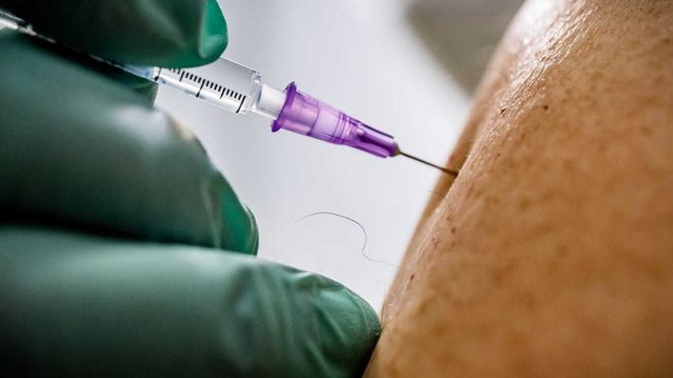 Ein Arzt verimpft eine Dosis des Biontech/Pfizer-Impfstoffs.