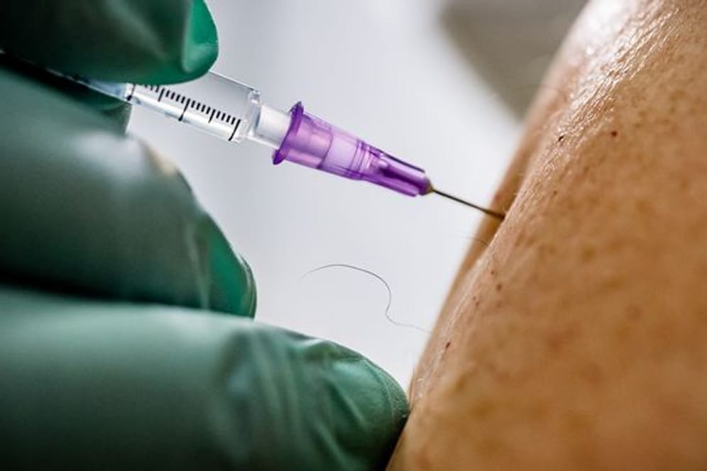 Ein Arzt verimpft eine Dosis des Biontech/Pfizer-Impfstoffs.