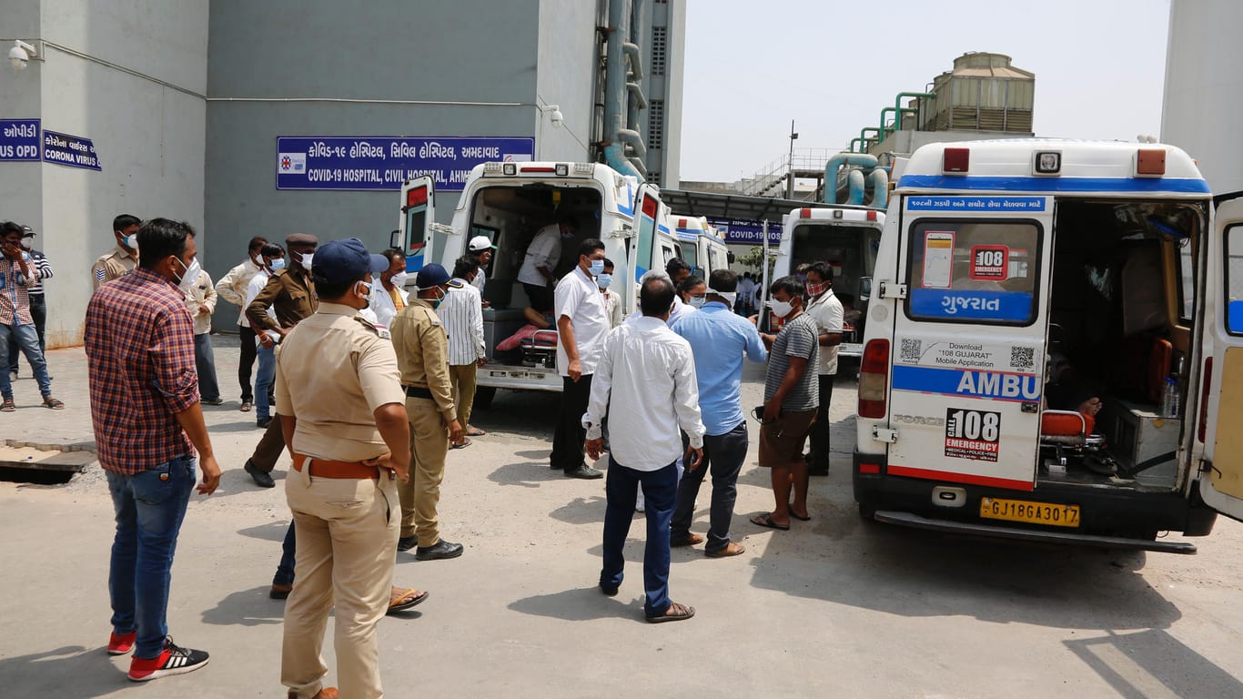 Angehörige diskutieren mit Rettungskräften vor einem Krankenhaus im indischen Ahmedabad: Das Land verzeichnet weltweit momentan die mit Abstand höchsten Infektionszahlen pro Tag.