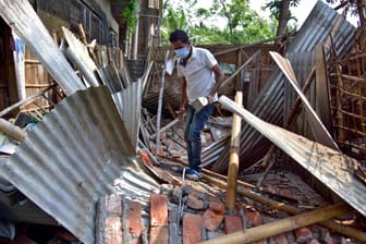 Ein Mann in der indischen Staat Nagaon läuft durch die Reste seines zusammengestürzten Hauses: Das Erdbeben erschütterte weite Teile des Nordostens.