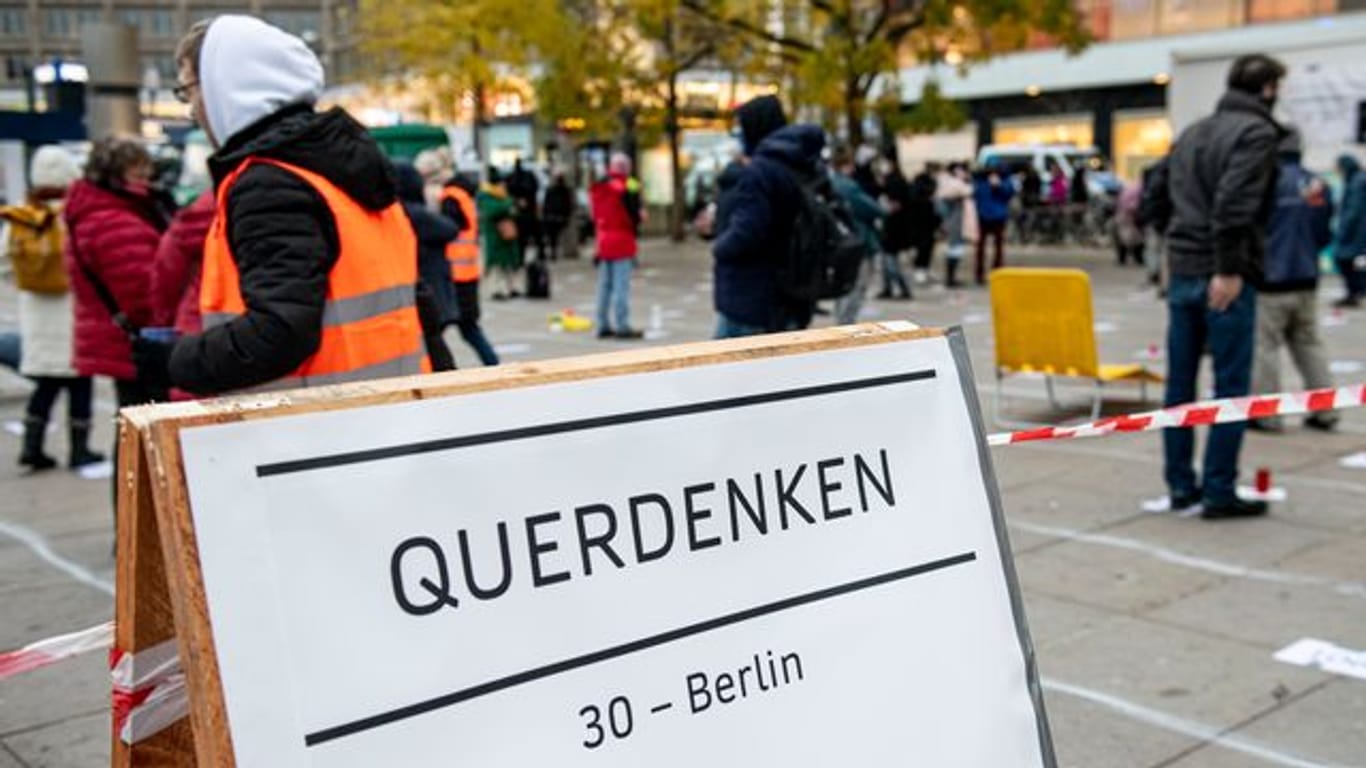 Teilnehmer stehen auf bei einer "Querdenker"-Demo gegen die Corona-Einschränkungen auf dem Alexanderplatz in Berlin (Archiv).