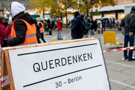 Teilnehmer stehen auf bei einer "Querdenker"-Demo gegen die Corona-Einschränkungen auf dem Alexanderplatz in Berlin (Archiv).