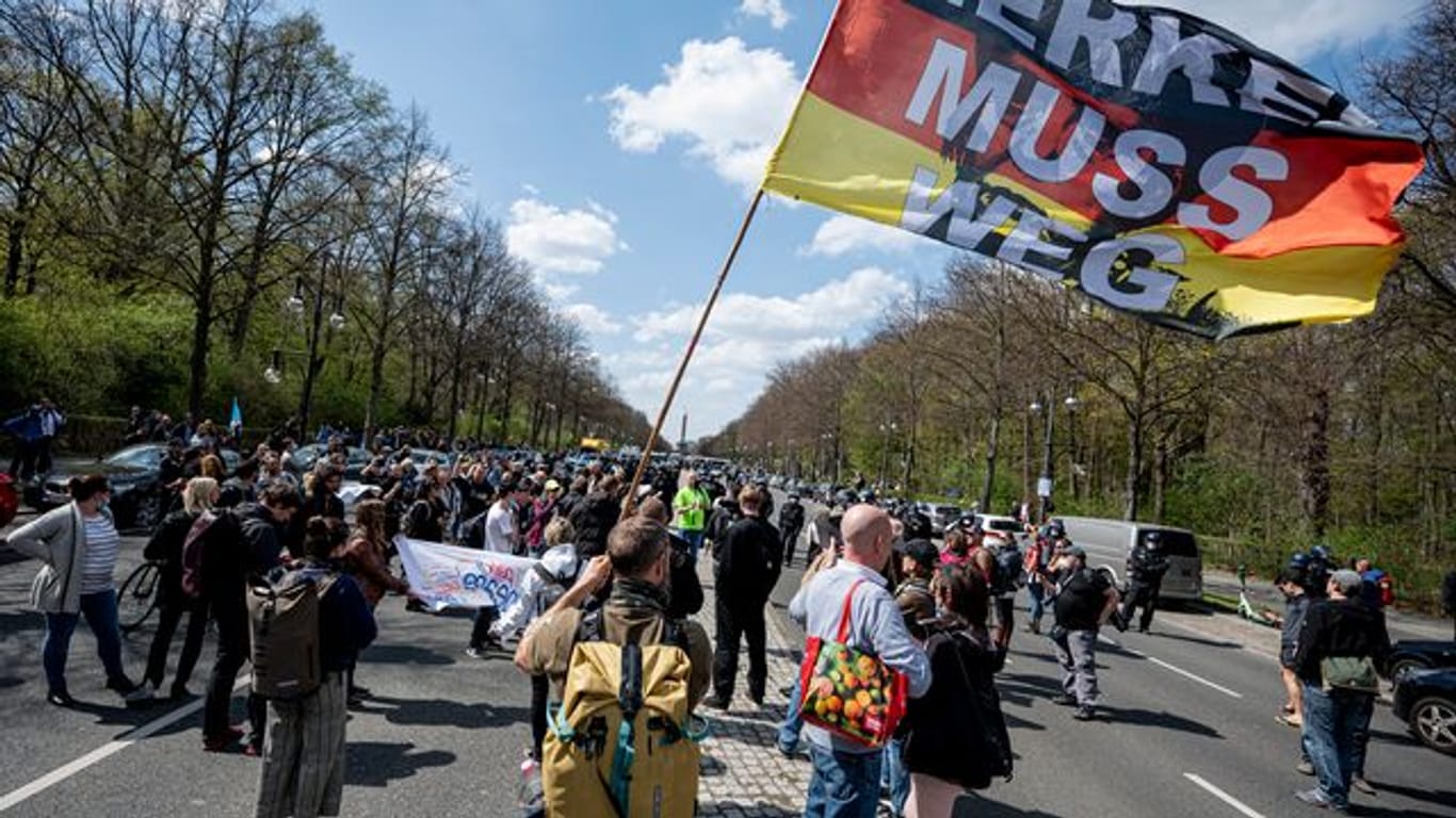 "Merkel muss weg" steht auf der Flagge eines Demonstranten beim Protest gegen die Änderung des Infektionsschutzgesetzes in Berlin am 21.