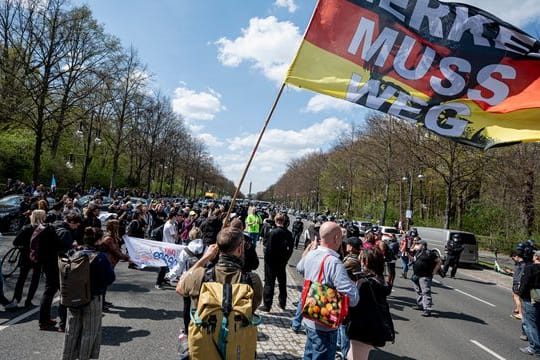 "Merkel muss weg" steht auf der Flagge eines Demonstranten beim Protest gegen die Änderung des Infektionsschutzgesetzes in Berlin am 21.