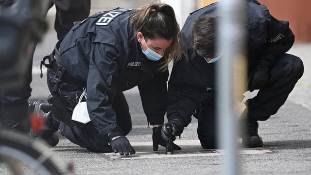 Polizisten suchen auf dem Fußweg und neben den Gebäuden des diakonischen Anbieters Oberlinhaus nach Spuren.