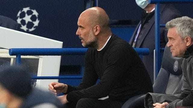 Pep Guardiola, Trainer von Manchester City, sitzt auf der Bank und beobachtet das Spiel.