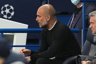 Pep Guardiola, Trainer von Manchester City, sitzt auf der Bank und beobachtet das Spiel.