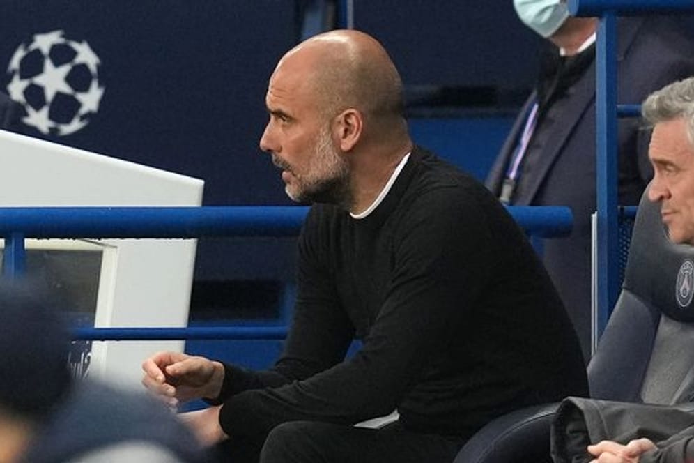 Pep Guardiola, Trainer von Manchester City, sitzt auf der Bank und beobachtet das Spiel.
