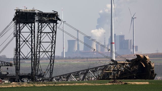 Ein Bagger gräbt am Tagebau Garzweiler, im Hintergrund das Braunkohlekraftwerk Niederaußem - und Windräder. Ein Bagger gräbt am Tagebau Garzweiler, im Hintergrund das Braunkohlekraftwerk Niederaußem - und Windräder.