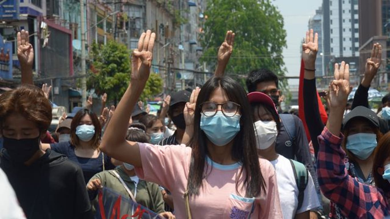 Anti-Putsch-Demonstranten zeigen während eines Protests in Rangun gegen die Militärregierung den Drei-Finger-Gruß als Zeichen des Protests.