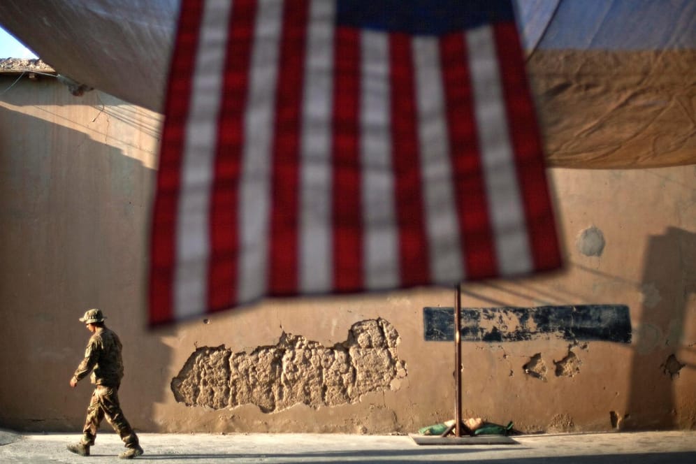 Ein US-Soldat geht an einer US-Fahne vorbei: Nach fast 20 Jahren Einsatz beginnt der offizielle Abzug der internationalen Truppen aus Afghanistan.