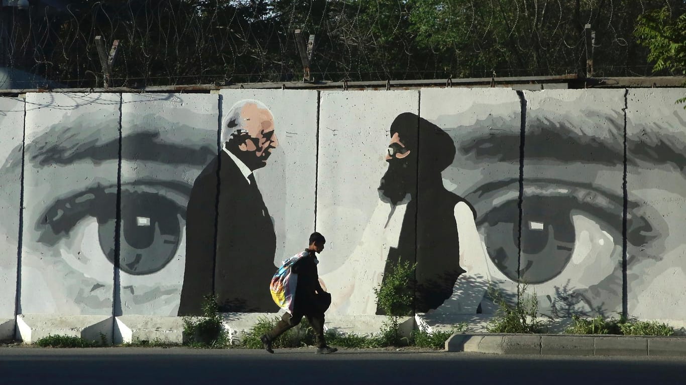 Ein Graffiti zeigt Washingtons Friedensgesandten Zalmay Khalilzad (l) und Mullah Abdul Ghani Baradar, den Anführer der Taliban-Delegation: Eigentlich hatten die Taliban zugesagt, ihre Verbindungen zu Al-kaida zu kappen.