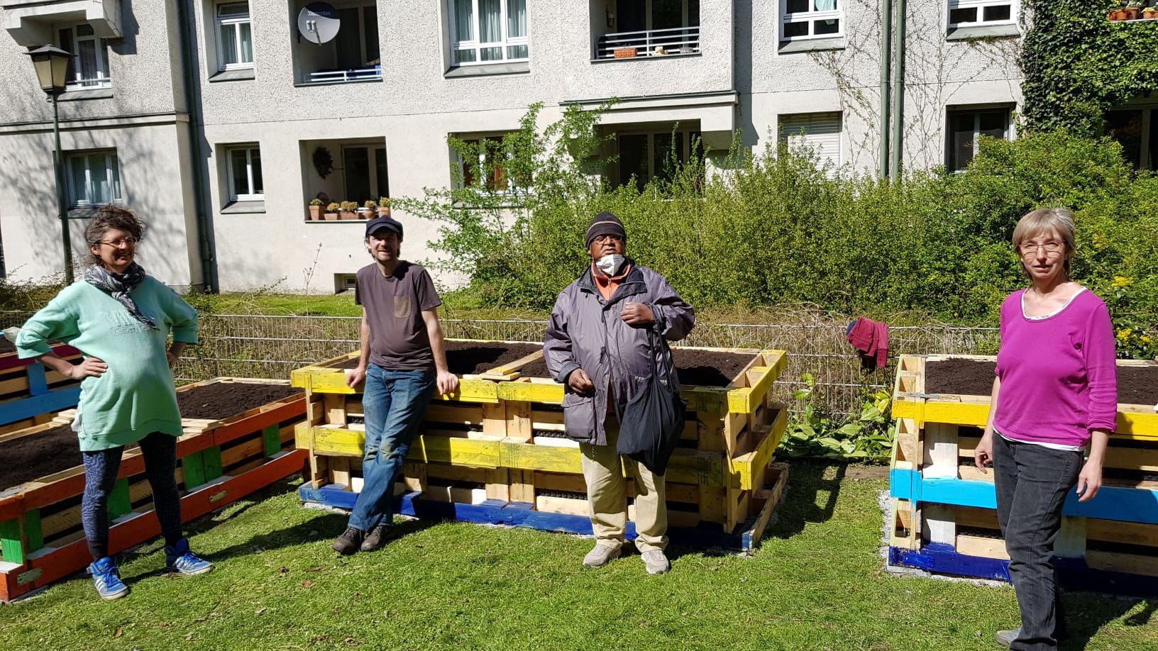 Die Nachbarschaftsgärtner vor ihren Hochbeeten: Ein lokaler Künstler hat die Holzkonstruktionen bemalt.