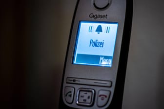 Bei einem klingelnden Telefon steht als Anrufer "Polizei" (Symbolbild): Eine falsche Polizistin hat bei einer 79-jährigen Kölnerin viel Geld erbeutet.