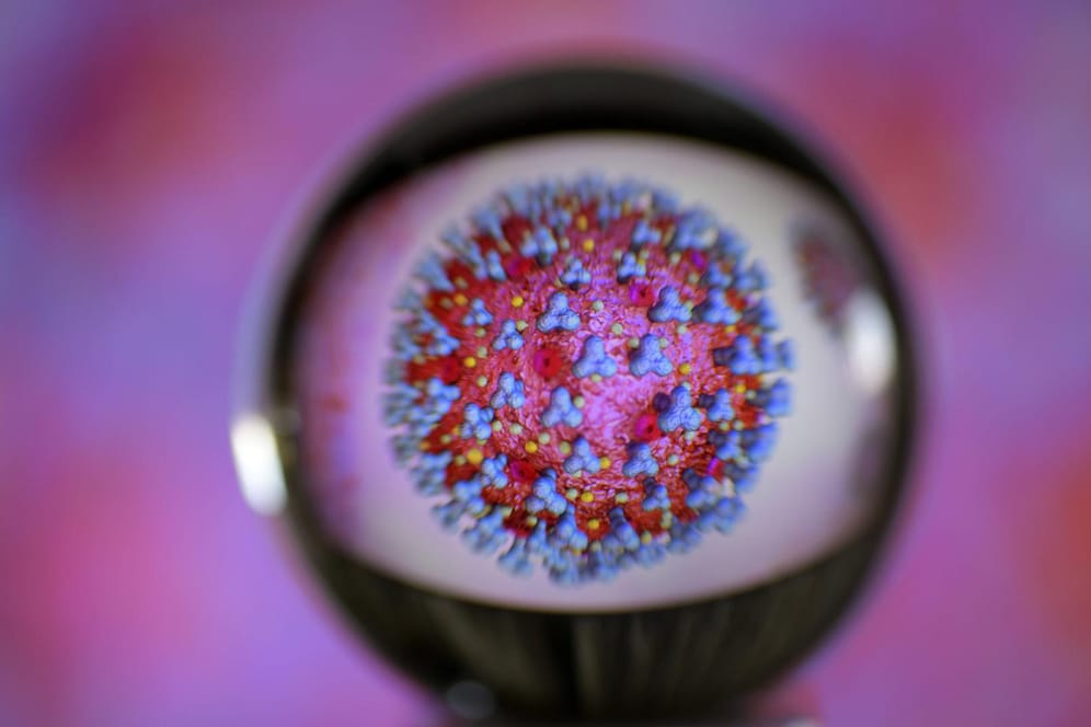 Visualisierung des Coronavirus hinter einer Glaskugel.
