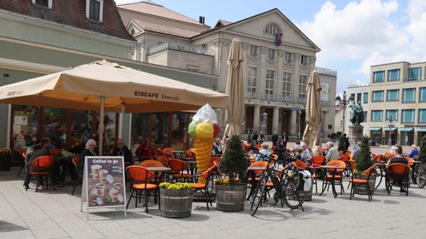 Gäste sitzen vor einem Cafe im Zentrum von Weimar (Archivbild): In Erfurt, Jena und Weimar ist Außengastronomie wieder möglich.