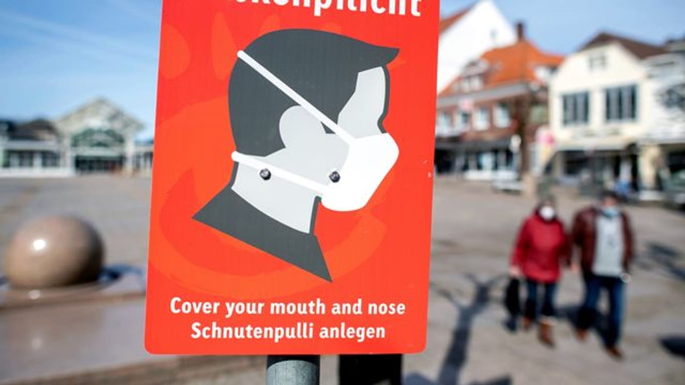 Ein Schild mit der Aufschrift "Maskenpflicht" hängt auf einem Platz (Symbolbild): Diese Corona-Maßnahme bleibt in Rheinland-Pfalz weiter bestehen.