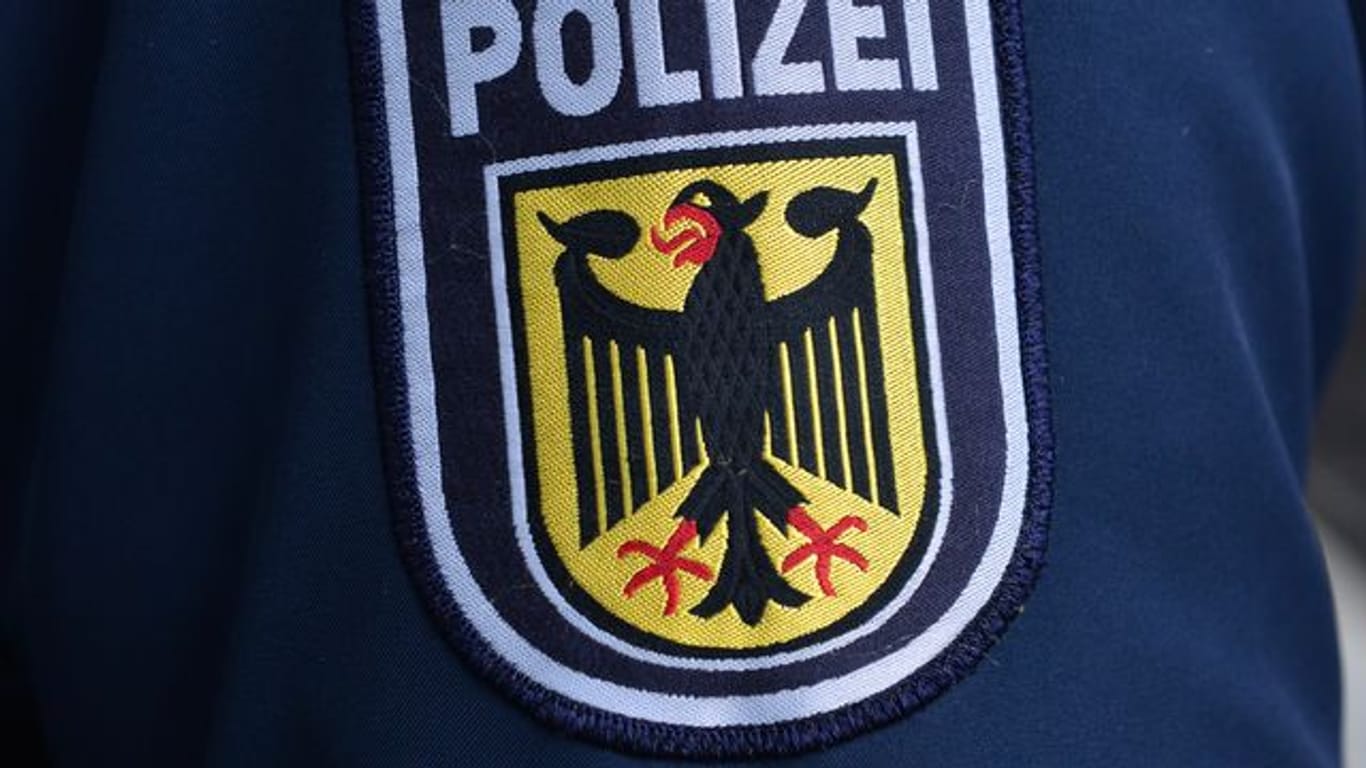 Das Wappen der Bundespolizei auf einer Dienstjacke (Symbolbild): Der Mann musste sich am Flughafen auf das Virus testen lassen.