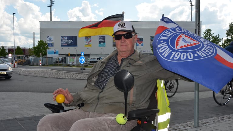 Horst Michelsen: Der 66-Jährige fährt mit Holstein-Kiel-Flaggen an seinem Rollstuhl durch Kiel.