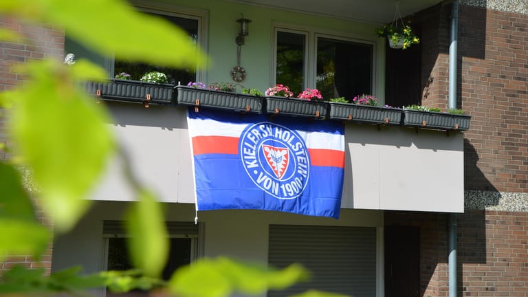 An einem Balkon hängt eine Flagge: Die Fan-Gruppe will dazu aufrufen, dass die ganze Stadt in den Farben des Vereins leuchtet.