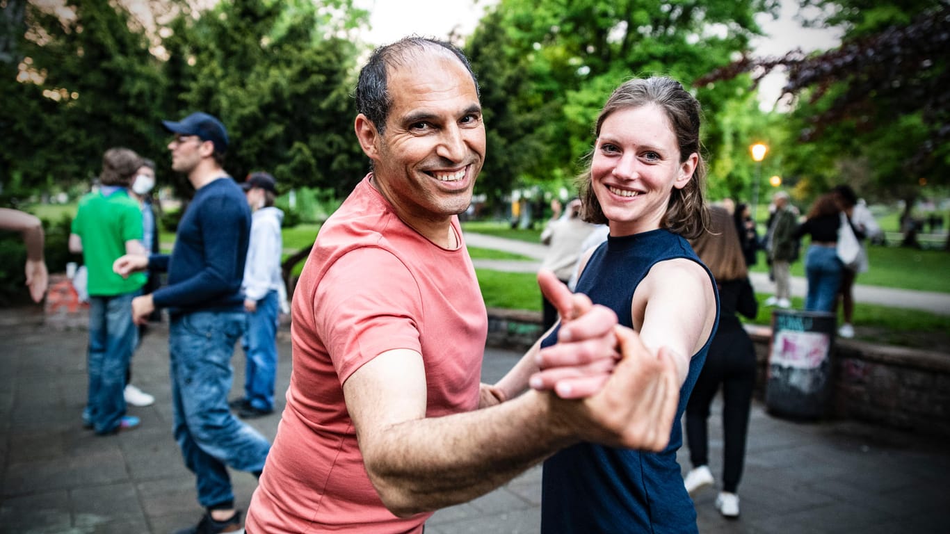 Menschen tanzen Standard zu lateinamerikanischer Musik im Weinbergspark: Viele Menschen zog es am Freitag auch in Berlins Parkanlagen.