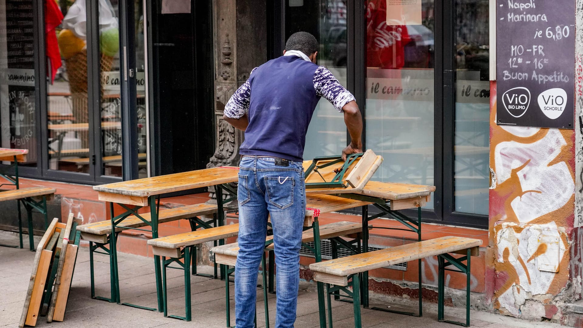 Hamburg: Ein Mitarbeiter eines Restaurants stellt im Hamburger Schanzenviertel Tische und Bänke auf. Außengastronomie und Einzelhandel dürfen in Hamburg unter Auflagen wieder öffnen.