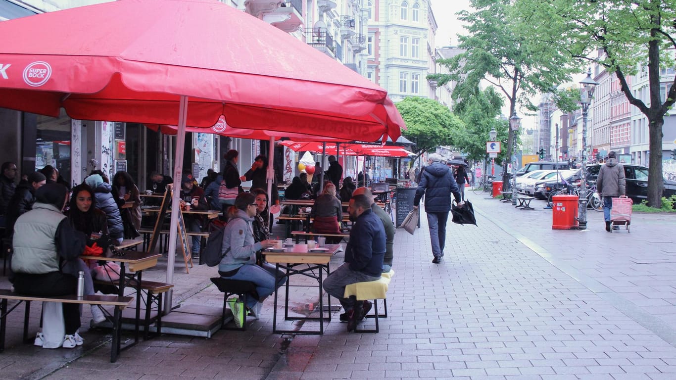 Hamburg: trotz Schmuddelwetter sitzen viele Menschen vor den Restaurants und genießen eine Mahlzeit oder ein Getränk.