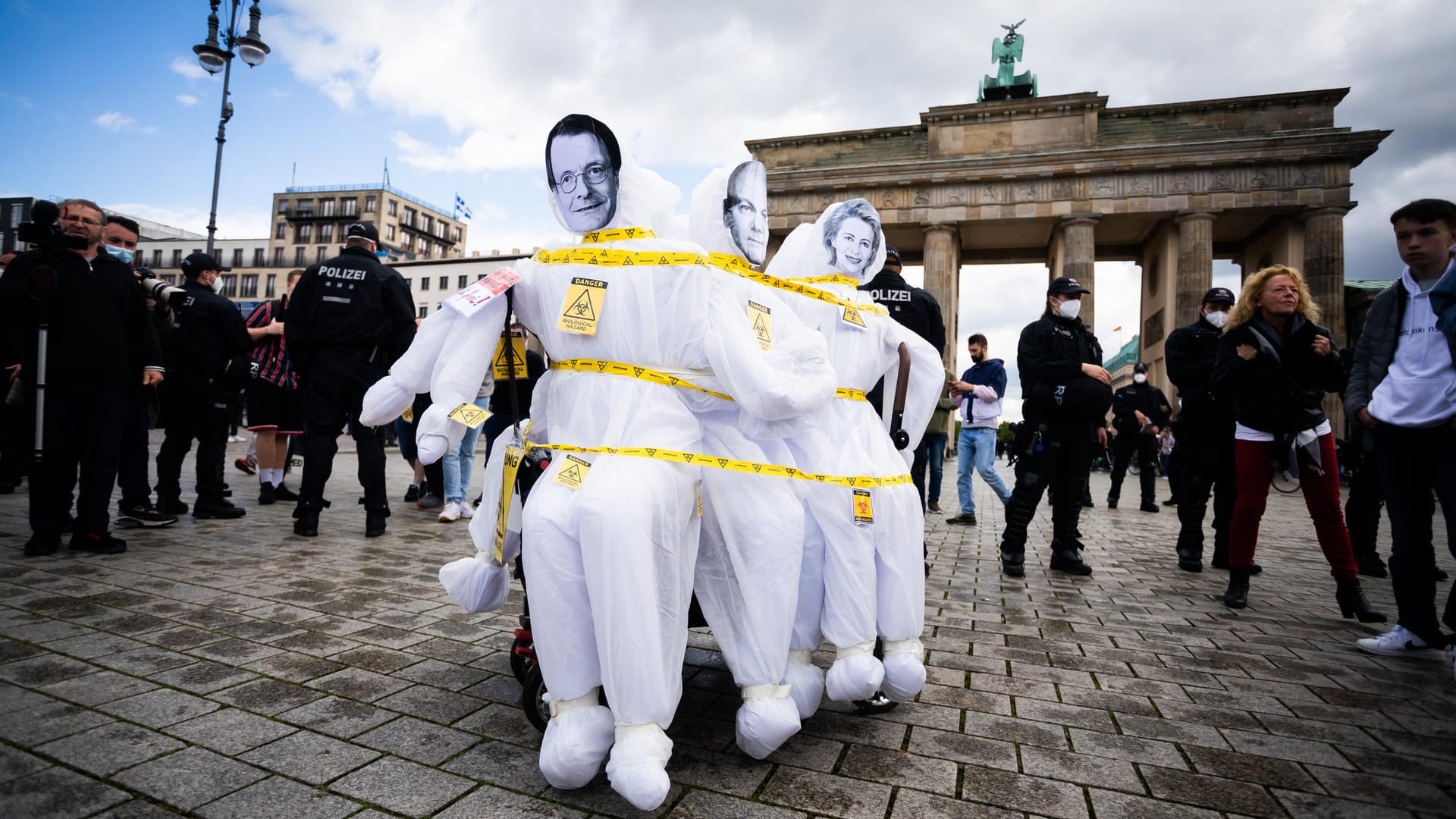 Auf einem Wagen mit "Schutzanzug-Puppen" sind bei einer Kundgebung gegen die Corona-Maßnahmen die Gesichter von SPD-Politiker Lauterbach, Vizekanzler Scholz und EU-Kommissionspräsidentin von der Leyen zu sehen: Trotz Demo-Verbots versammelten sich Hunderte Menschen in der Innenstadt.