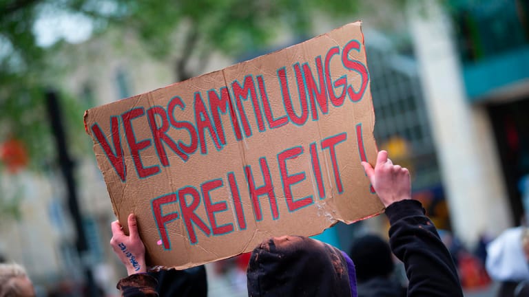 Ein Teilnehmer hält ein Schild in die Höhe: In Köln gab es eine Demonstration zum Motto "Versammlungsgesetz NRW stoppen – Grundrechte erhalten".