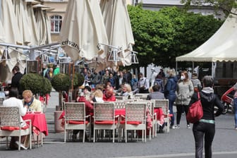 Gäste sitzen vor einer Gaststätte im Zentrum: Seit Samstag dürfen in der Stadt die Außenbereiche der Gastronomie wieder für Gäste öffnen.