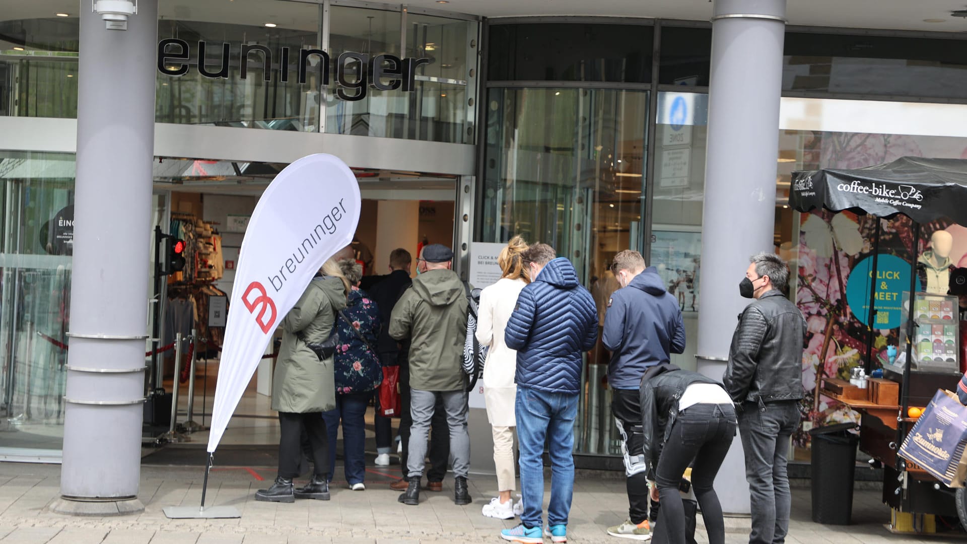 Vor einem Bekleidungsgeschäft in der Innenstadt stehen Menschen und warten auf Einlass: Auch vor einem Corona-Testzentrum kam es zu Warteschlangen.