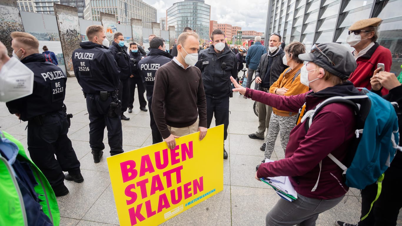 Sebastian Czaja, stellvertretender Landesvorsitzender der FDP in Berlin und Spitzenkandidat für die Abgeordnetenhauswahl 2021, und Karin Baumert, Anmelderin der Demonstration, unterhalten sich am Rande einer Demonstration unter dem Motto "Gegen den Mietenwahnsinn – jetzt erst recht!": Czaja hält dabei ein Schild mit der Aufschrift "Bauen statt klauen".