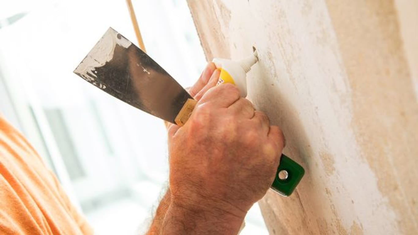 Löcher in der Wand können Heimwerker mit einer fertigen Spachtelmasse verschließen, Gips zum Anrühren ist meist günstiger.