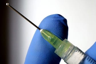 Eine Flüssigkeit tropft aus der Kanüle einer Spritze (Symbolbild): Arztpraxen bekommen aktuell nur eine oder zwei Flaschen des Impfstoffes pro Woche.