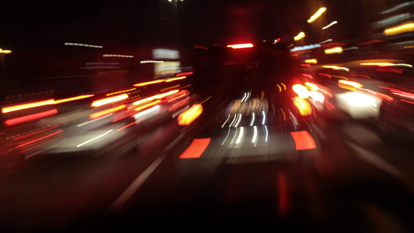 Bewegungsunscharf fotografierte Autos von hinten mit roten Brems- und Rücklichtern Bewegungsunscharf fotografierte Autos