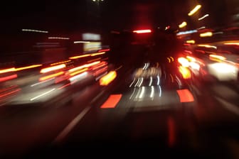 Bewegungsunscharf fotografierte Autos von hinten mit roten Brems- und Rücklichtern Bewegungsunscharf fotografierte Autos