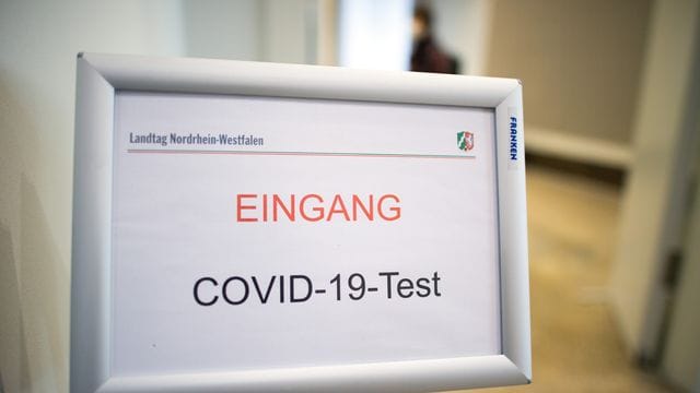 Ein Schild weist auf den Eingang zu einem Covid-19-Testcenter hin.